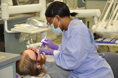 Dental Hygiene student cleaning a fellow students teeth